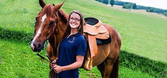student with saddled horse